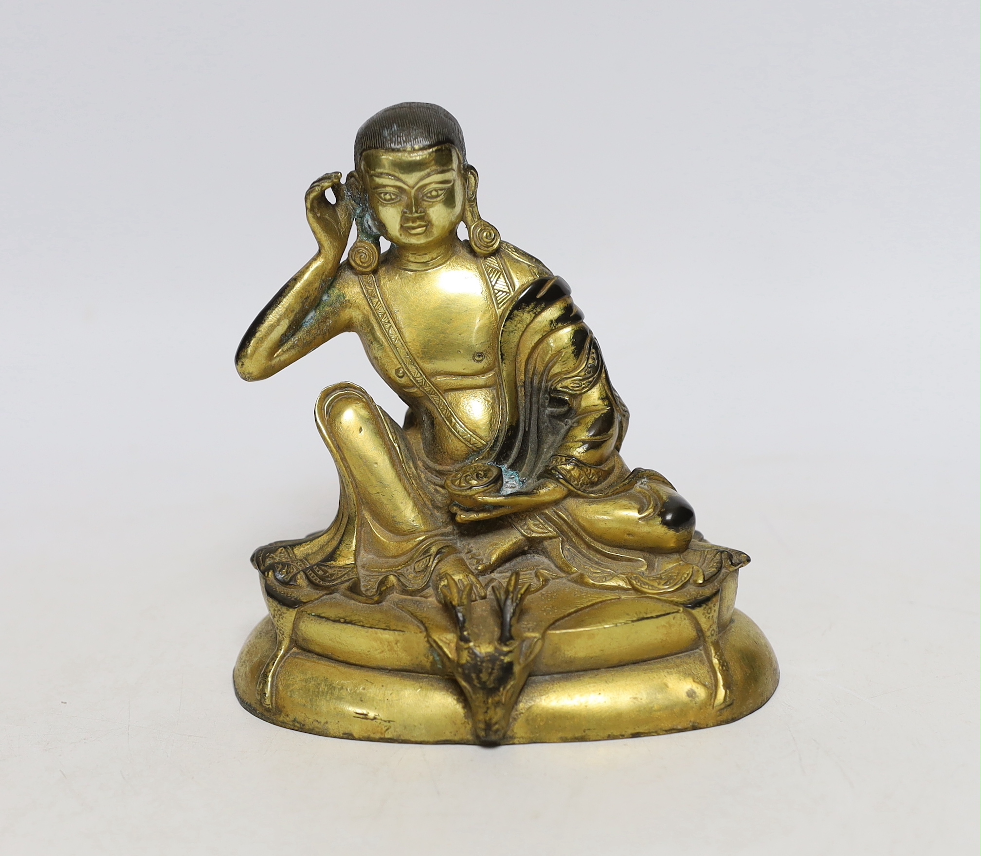 A Sino-Tibetan gilt bronze seated figure of Milarepa, 14cm high